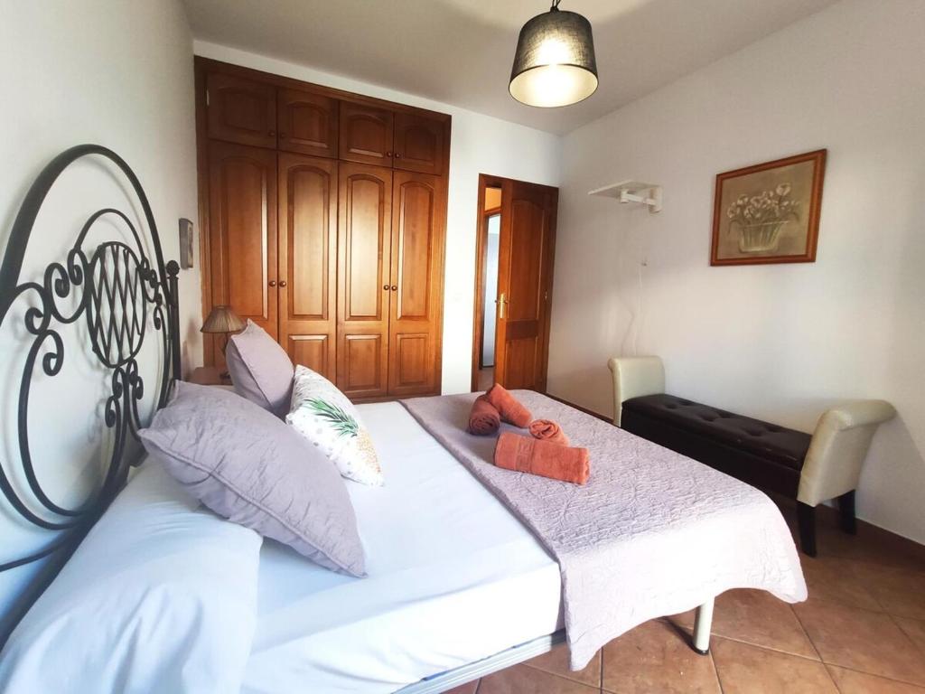 - une chambre avec un lit doté de draps et d'oreillers blancs dans l'établissement La Chalana, à Arrecife
