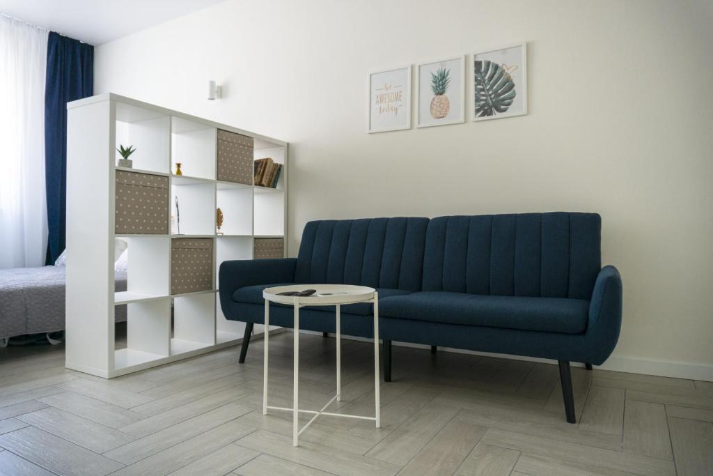 a living room with a blue couch and a table at Arkadia apt in Odesa