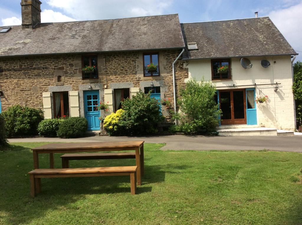 a bench in front of a stone house at La Cahudiere in Saint-Martin-Landelles