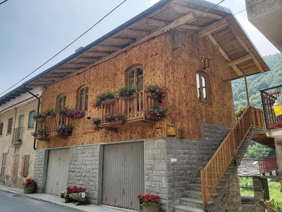 a building with flowerpots on the side of it at Chalet MariBru in Pradleves