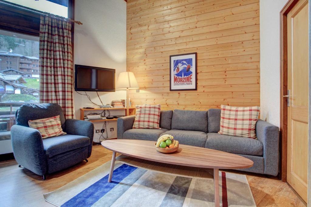 ein Wohnzimmer mit einem Sofa und einem Tisch in der Unterkunft La Corniche in Morzine