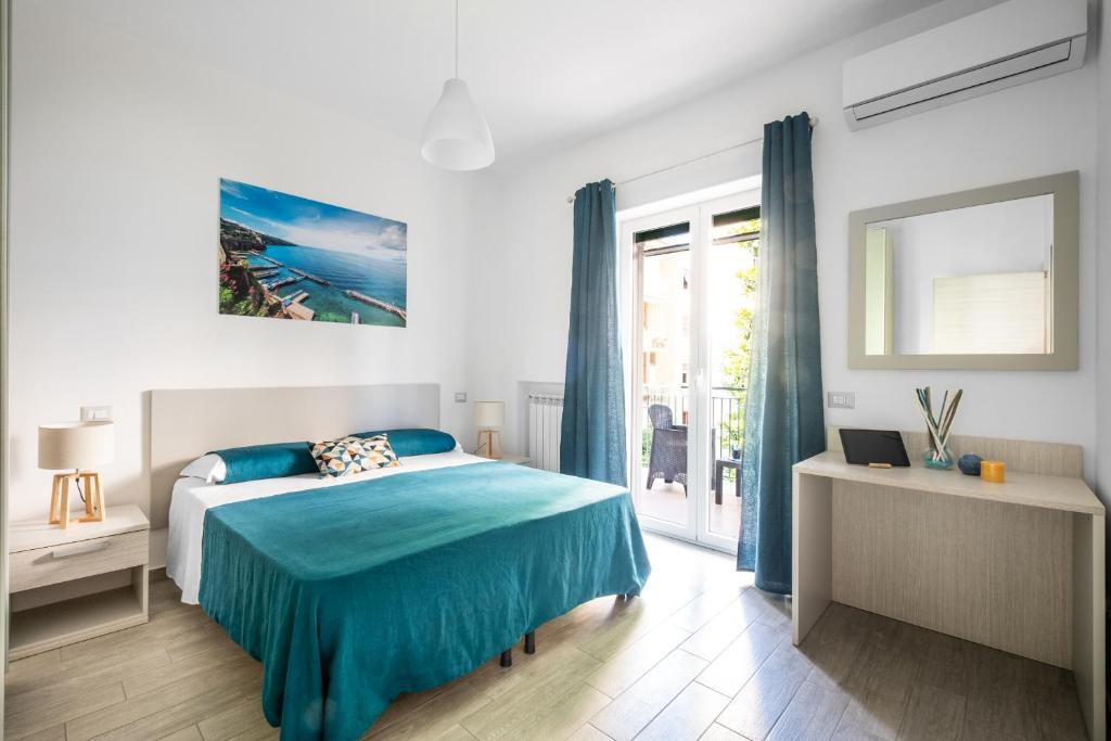 a bedroom with a blue bed and a window at Dreamers' House Sorrento in Sorrento