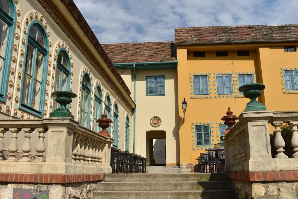 a building with a staircase in front of it at Zsolnay Negyed Vendégháza in Pécs