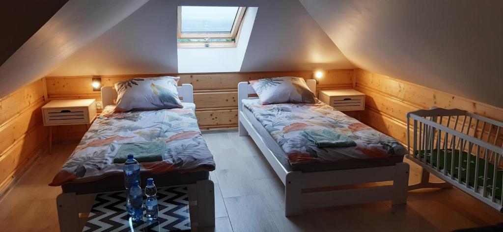 a attic room with two beds and a window at Panorama Świętokrzyska in Górno