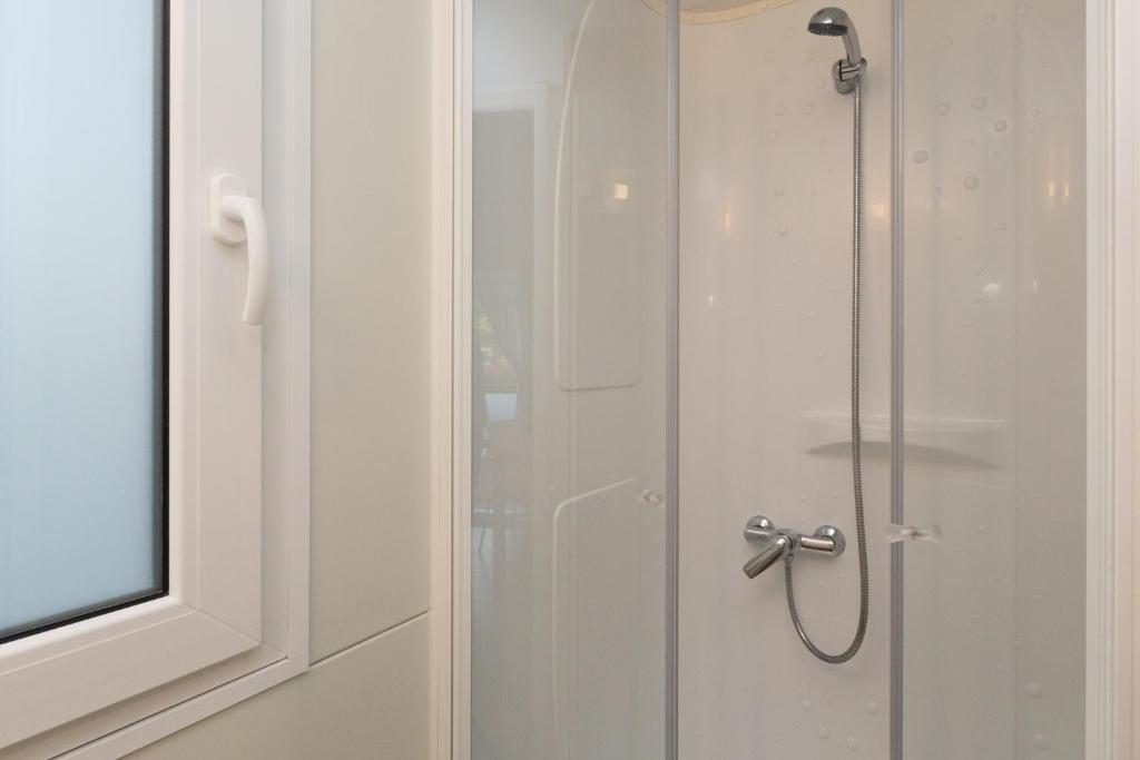 a shower with a glass door in a bathroom at Mobile Homes Banko in Bijela Uvala and Zelena laguna in Poreč
