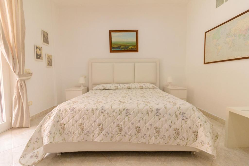 Dormitorio blanco con cama con edredón en Maison Lillina, en Sorrento