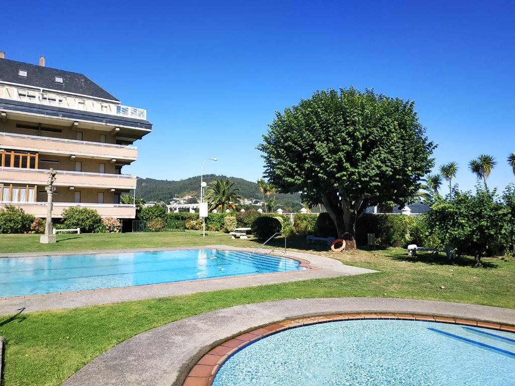 basen przed dużym budynkiem w obiekcie Covas Beach Jardín w mieście Viveiro