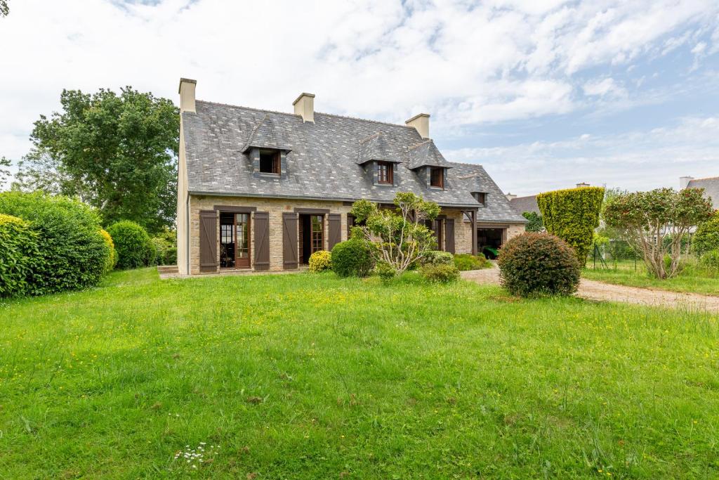 una casa antigua con un patio verde en Ker Ys en Plonévez-Porzay