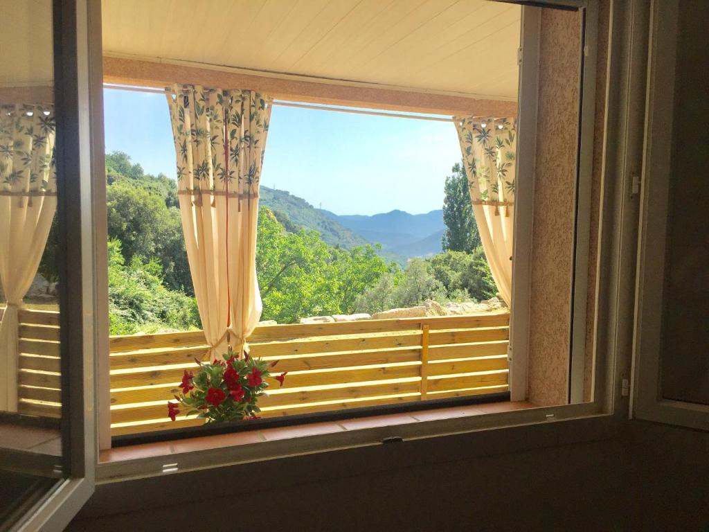 - une fenêtre avec vue sur la montagne dans l'établissement CASA CRISTINA Charmant Appartement CALME ENTRE MER ET MONTAGNE, à Santa-Lucia-di-Tallano