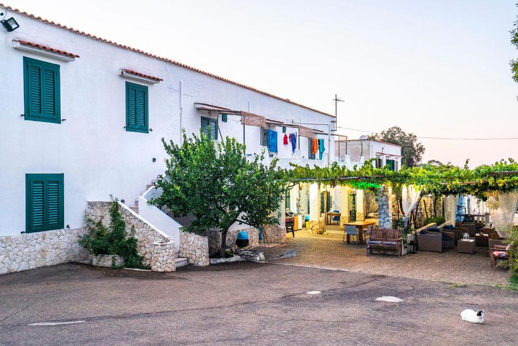 un edificio bianco con finestre con persiane verdi di Casa Colletta Vieste a Vieste