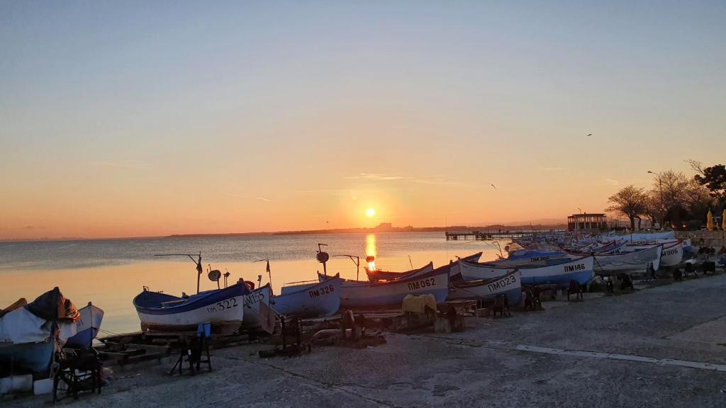 a group of boats parked on the beach at sunset at Pomorie Beach Resort in Pomorie