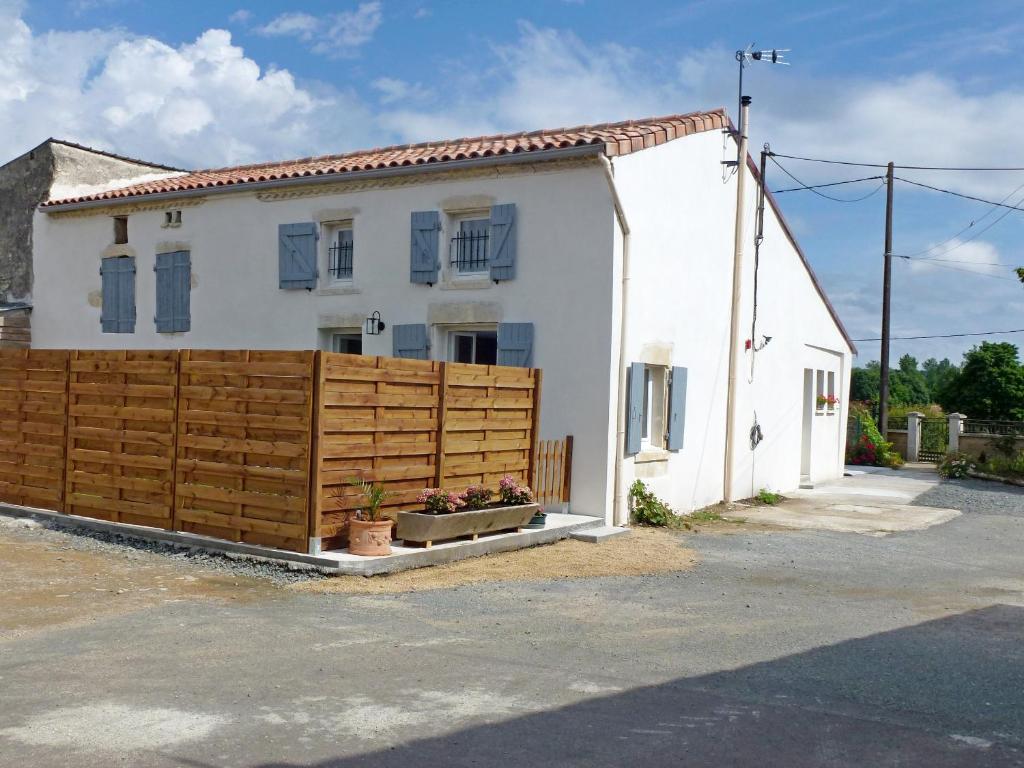 una casa blanca con una valla de madera delante de ella en Maison de campagne "Beun'aise", en Val-du-Mignon