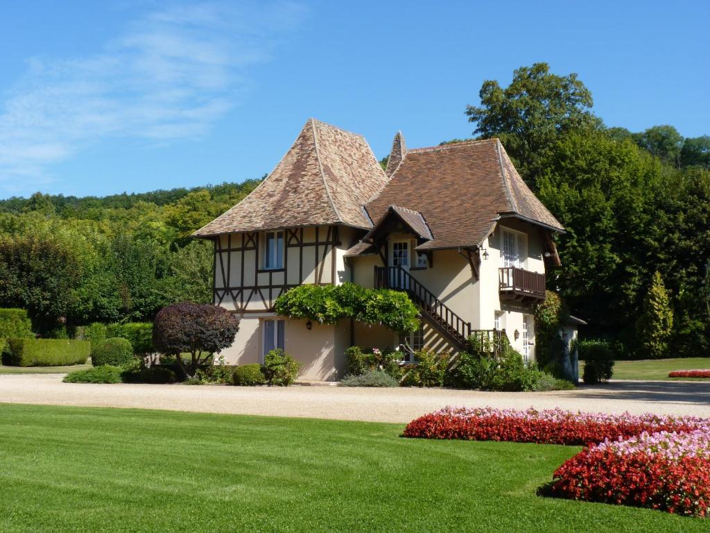 a house with a thatched roof and some flowers at Domaine de la Reposée in Fermaincourt