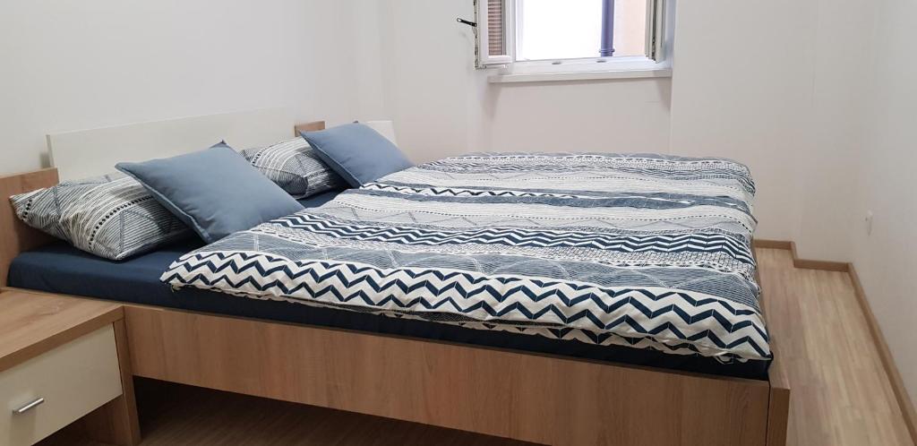 ein Bett mit einer blauen und weißen Decke drauf in der Unterkunft Tincha in Piran