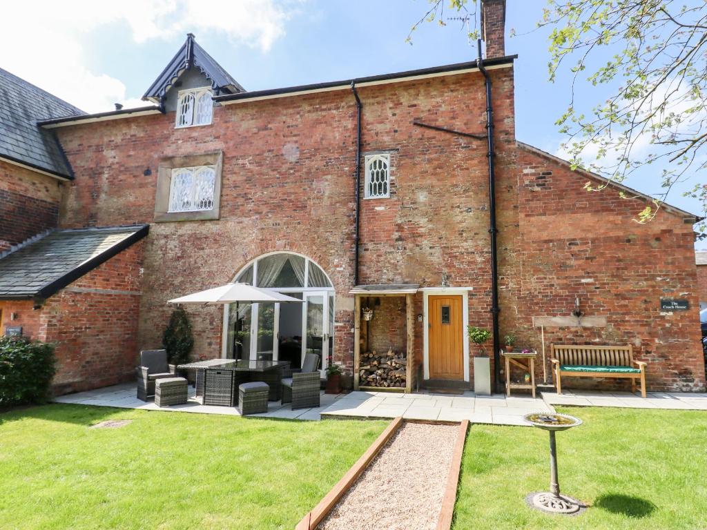 an exterior view of a brick building with a patio at The Coach House in Oakamoor