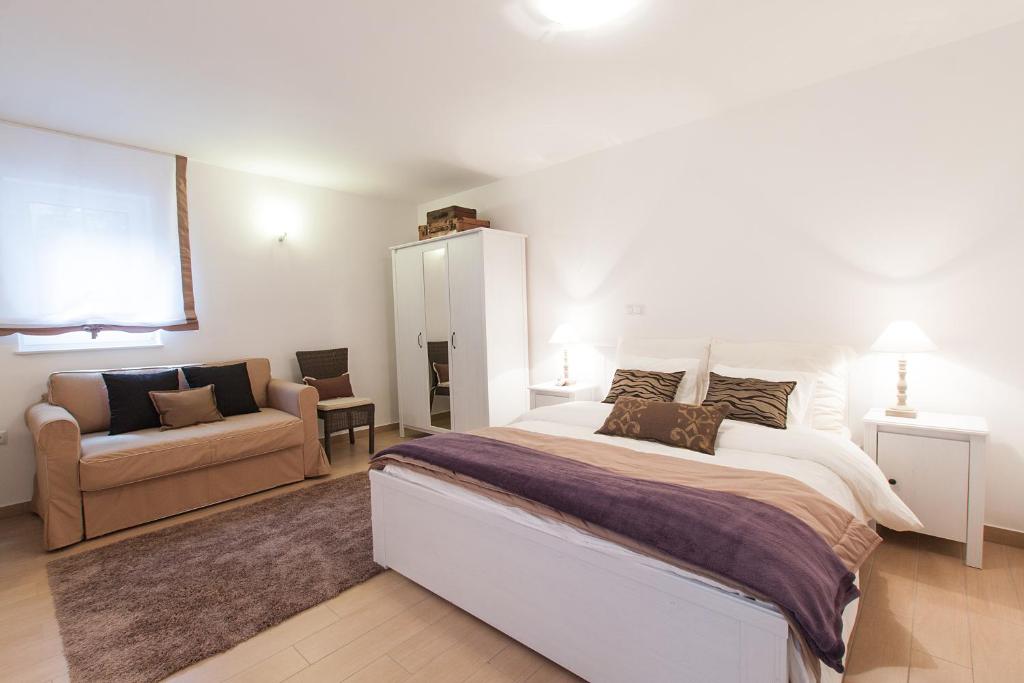 1 dormitorio con 1 cama grande y 1 sofá en Effie Perine Apartments, en Bled
