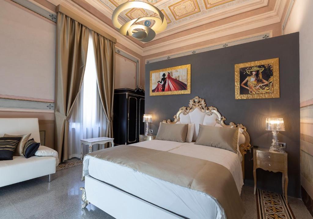 a bedroom with a large bed and a chandelier at Luxury Liberty House in Alghero