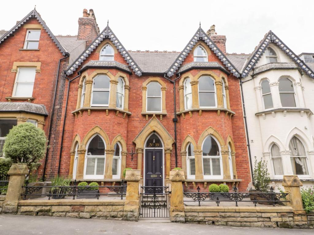 a large red brick house with a black door at 39 West Street in Scarborough