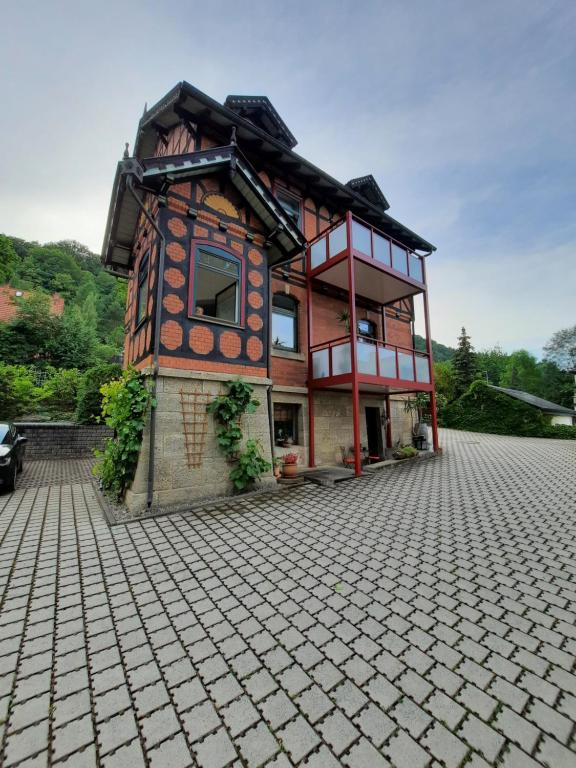 a building on a cobblestone street in front at Ferienwohnung Villa Frosch in Meiningen