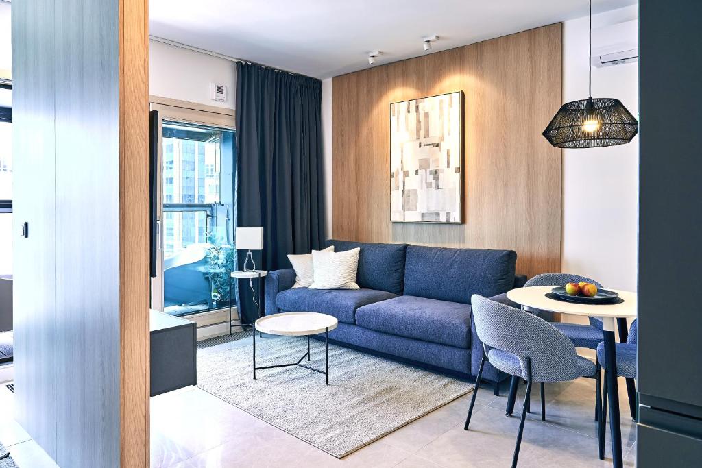 een woonkamer met een blauwe bank en een tafel bij Mennica Residence I in Warschau