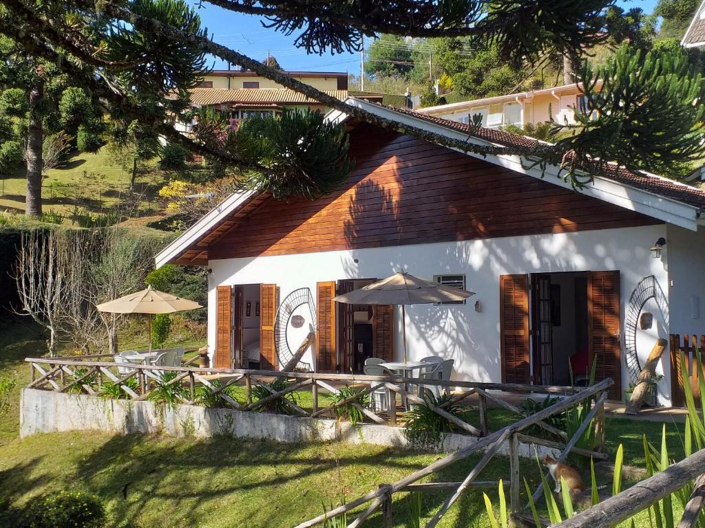 una casa blanca con mesas y sombrillas en Piccolo Borgo Antico - Il Cantuccio, en Campos do Jordão