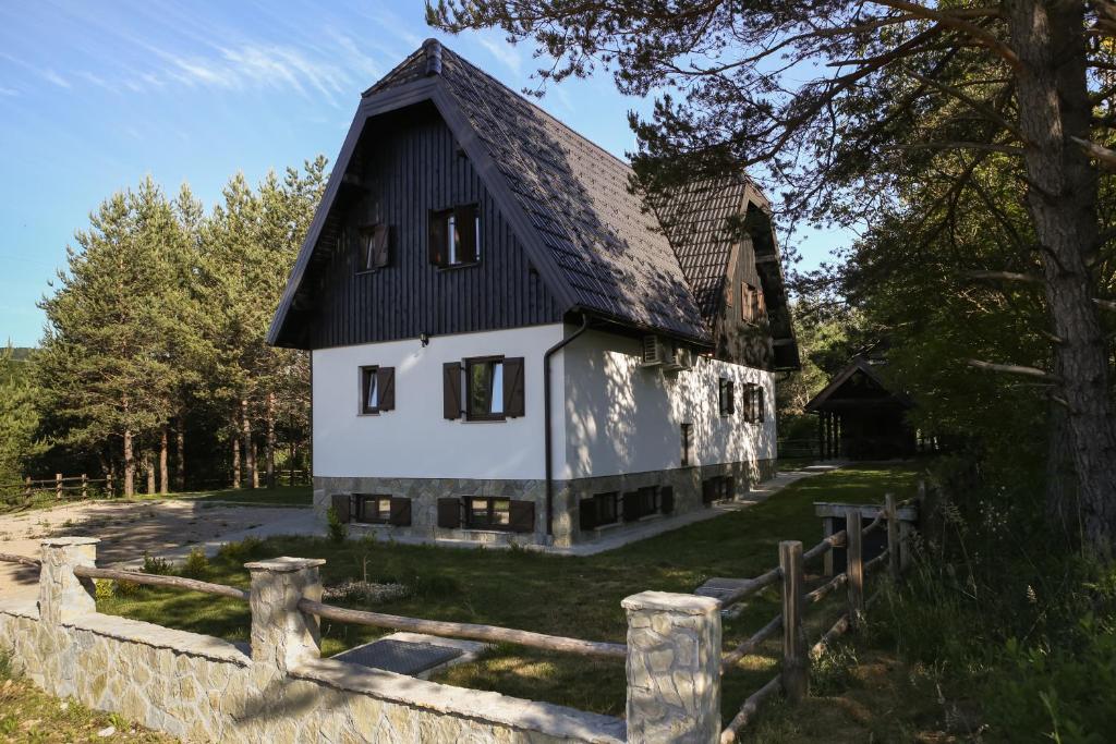 duży biały dom z czarnym dachem w obiekcie Timber valley w mieście Jeziora Plitwickie