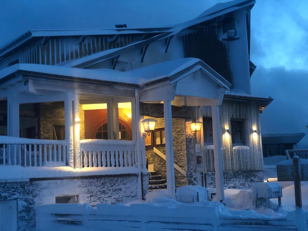 une maison recouverte de neige la nuit dans l'établissement Chaume de Balveurche, à Xonrupt-Longemer