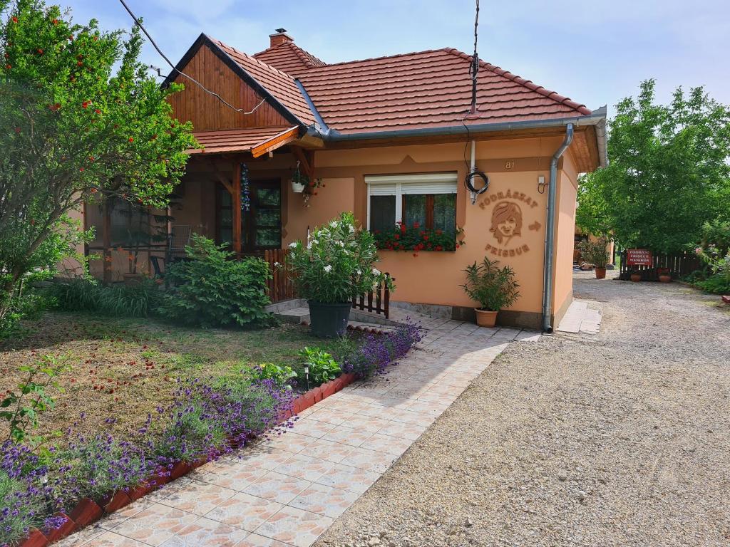 una pequeña casa con flores delante en Kriszta apartman en Balatongyörök