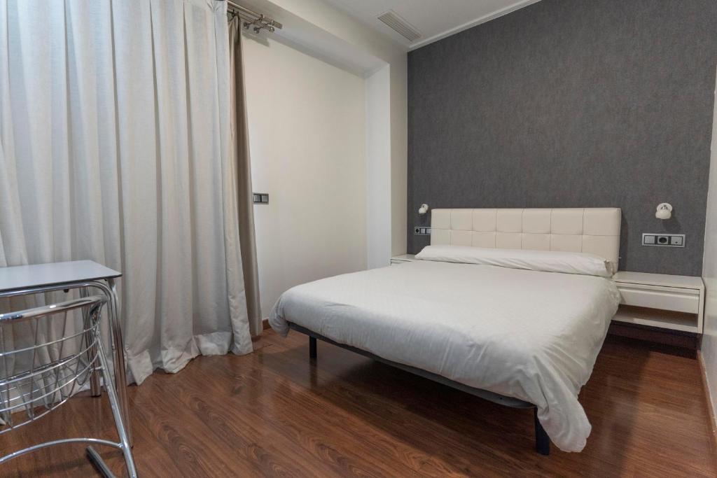 a bedroom with a white bed in a room at Hotel Lluna in Alzira