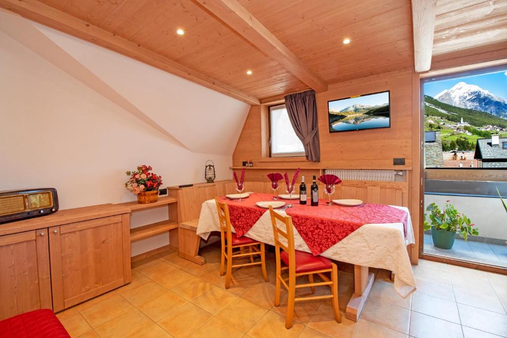 a dining room with a table and a tv at Casa Viola Lodge in Valdidentro