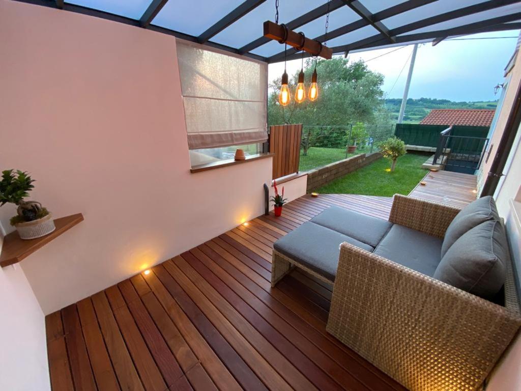 - une terrasse avec un canapé et des chaises sur du parquet dans l'établissement Apartma Sova Koper, à Koper