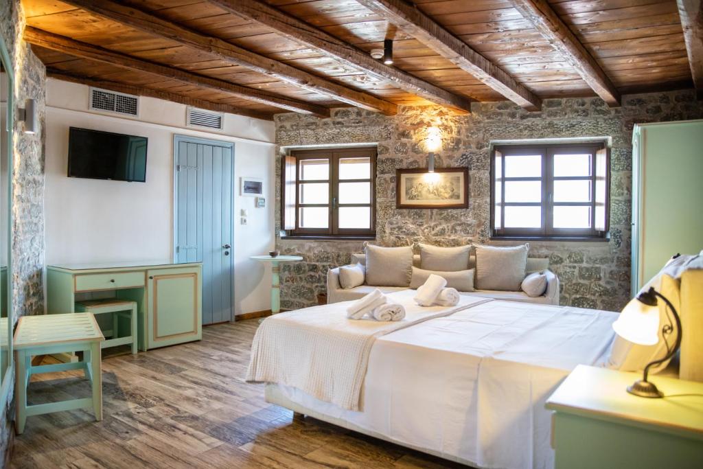 een slaapkamer met een groot wit bed in een kamer bij Trapela Areopolis, Boutique Hotel in Areopolis