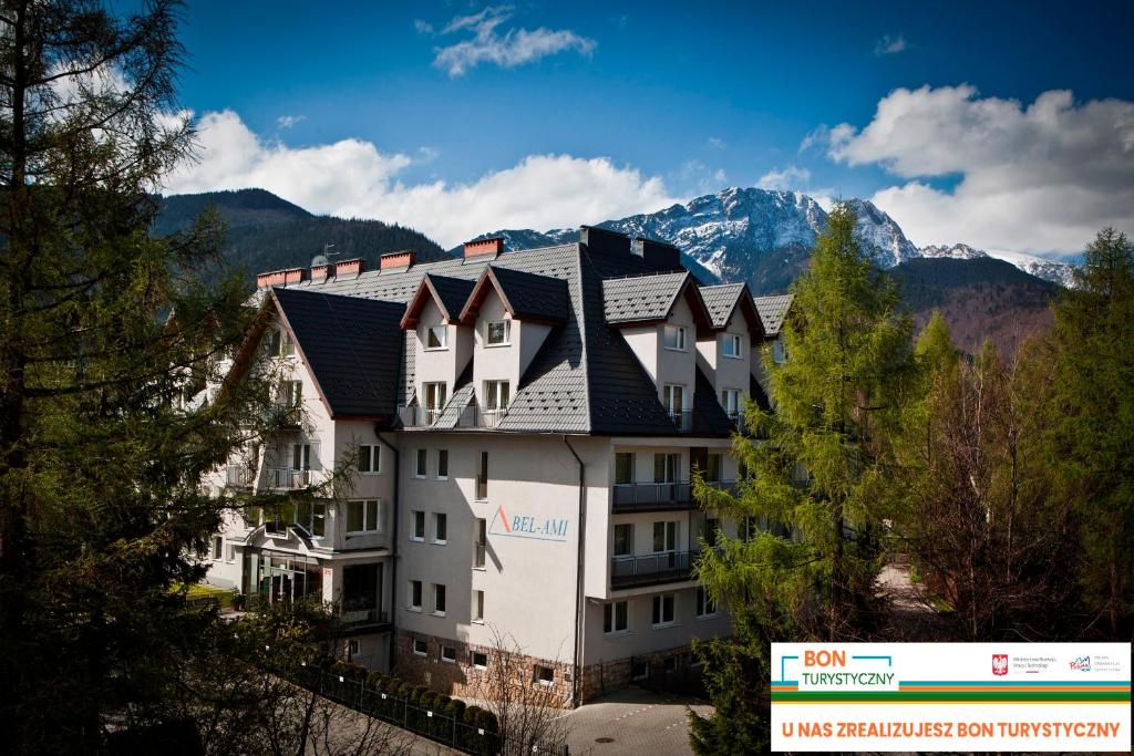 a large building with mountains in the background at Bel-Ami in Zakopane