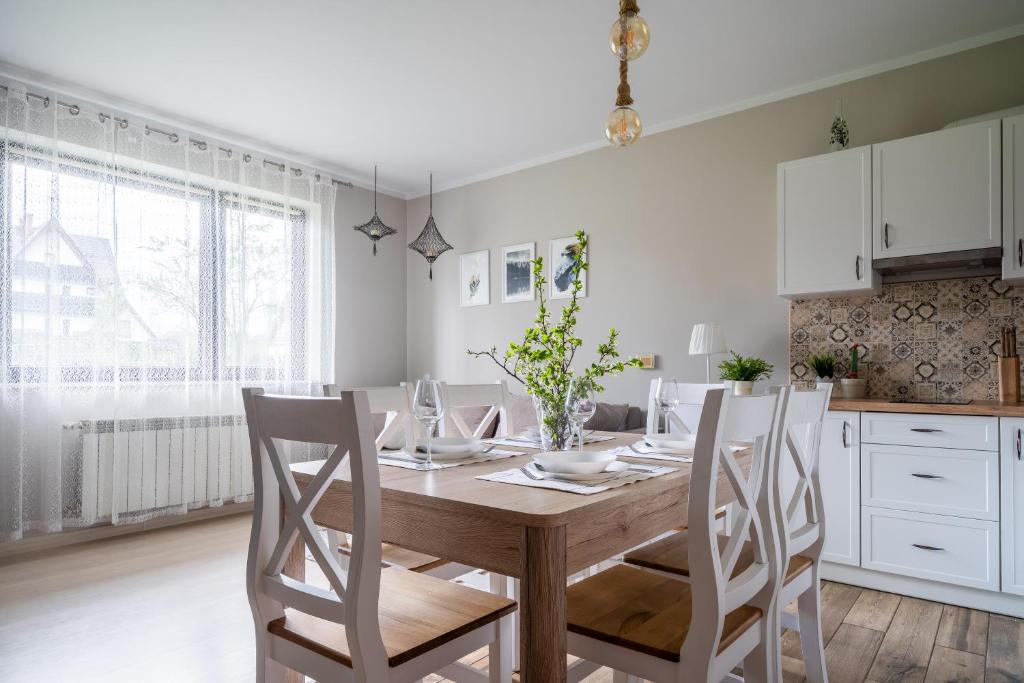 a dining room with a wooden table and chairs at Apartament Konda in Białka Tatrzańska