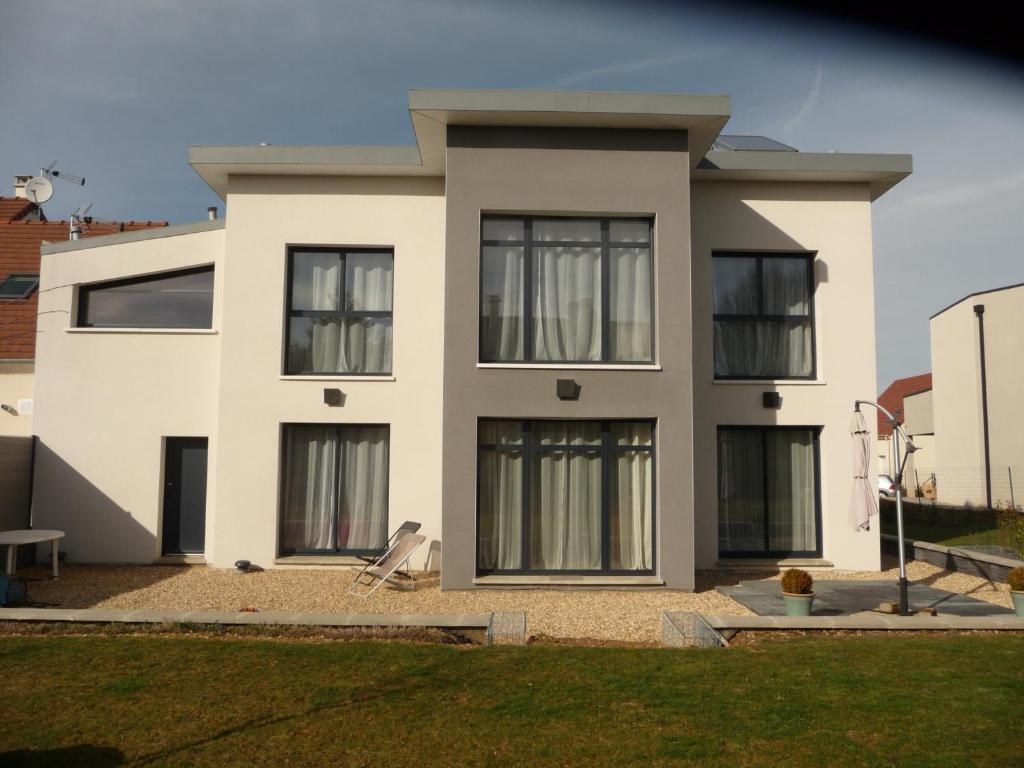 Casa blanca con ventanas negras en Chambres d'hôtes dans maison contemporaine en Vernouillet