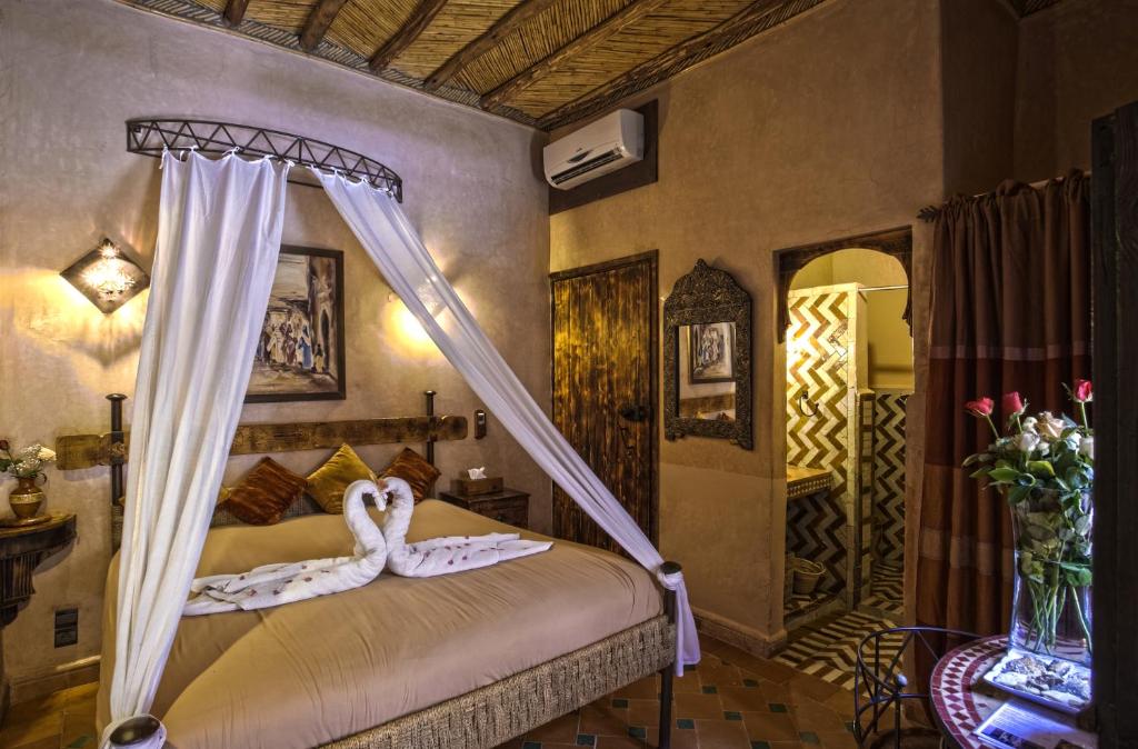 a bedroom with a bed with two swans on it at Hotel Kasbah Le Mirage & Spa in Marrakech