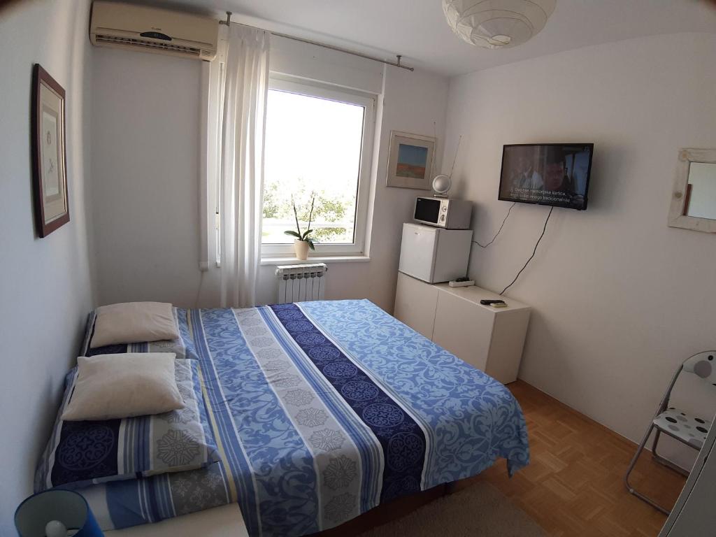mała sypialnia z łóżkiem i oknem w obiekcie Rooms Vukovarska w Zagrzebiu