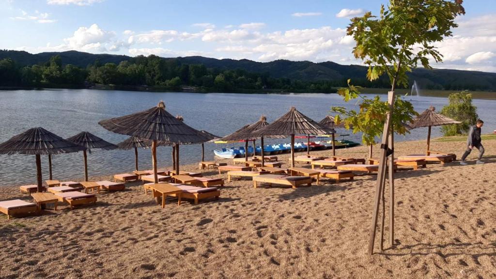 una spiaggia con molte sedie e ombrelloni di Apartmani K&V a Veliko Gradište
