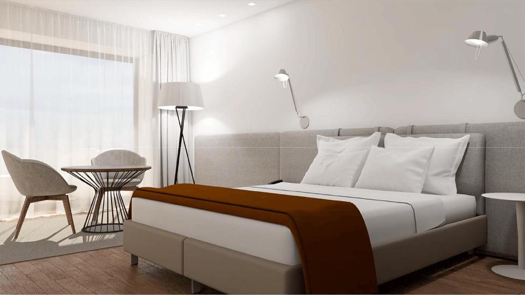 um quarto com uma cama, uma mesa e uma cadeira em Hotel Flor De Sal em Viana do Castelo