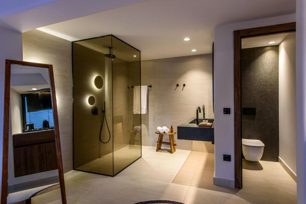 a bathroom with a shower and a toilet and a sink at Soleil Rooms and Suites in Stalís