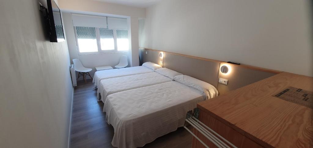 A bed or beds in a room at Apartamentos Costa da Morte Muxia