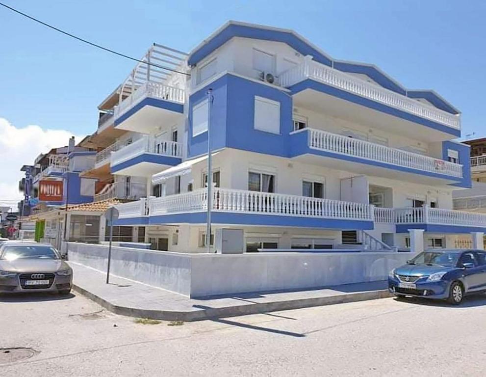 a blue building with cars parked in front of it at M&M BLUE LUXURY in Paralia Katerinis