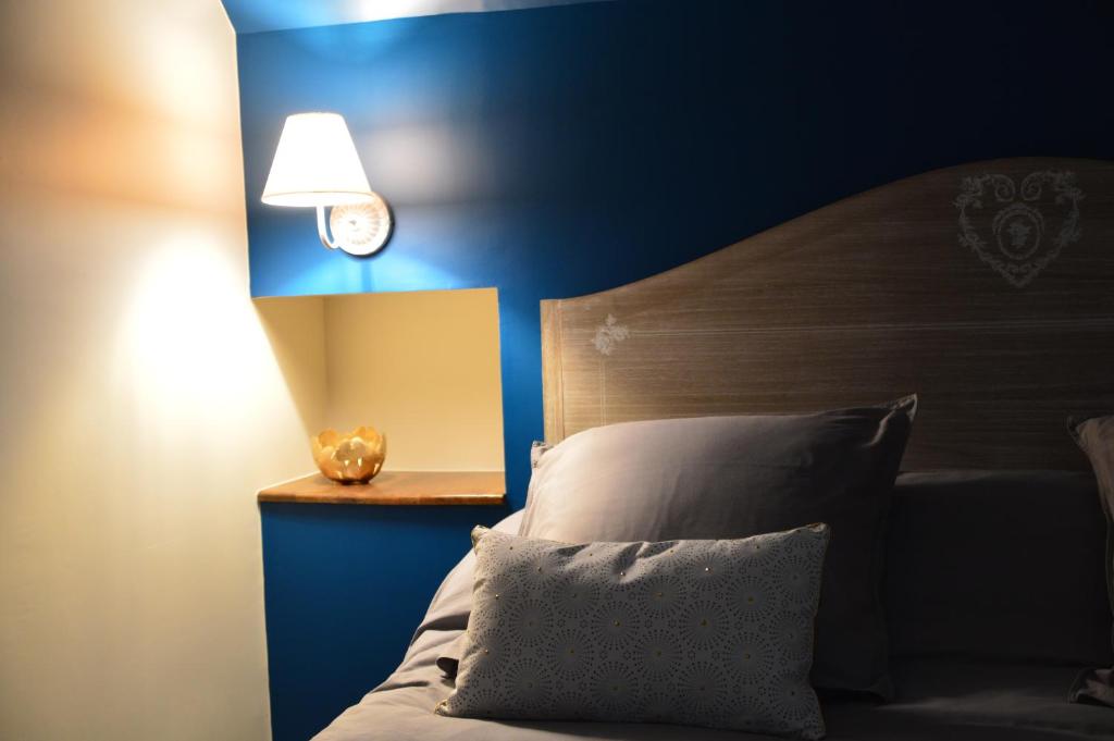 a bedroom with a bed and a blue wall with a clock at LA MAISON DE TRIBOULET Chambres et table d'hôtes -Amboise- in Pocé-sur-Cisse