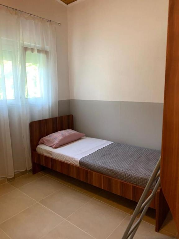 mała sypialnia z łóżkiem i oknem w obiekcie Ferienhaus "Arizones", Nea Kallikratia, Chalkidiki w miejscowości Nea Kallikratia