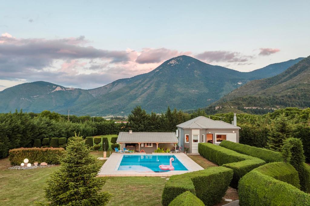 a house with a swimming pool in a yard with mountains at Villa Stymfalia - Luxury Mansion with Private Pool in Kartérion