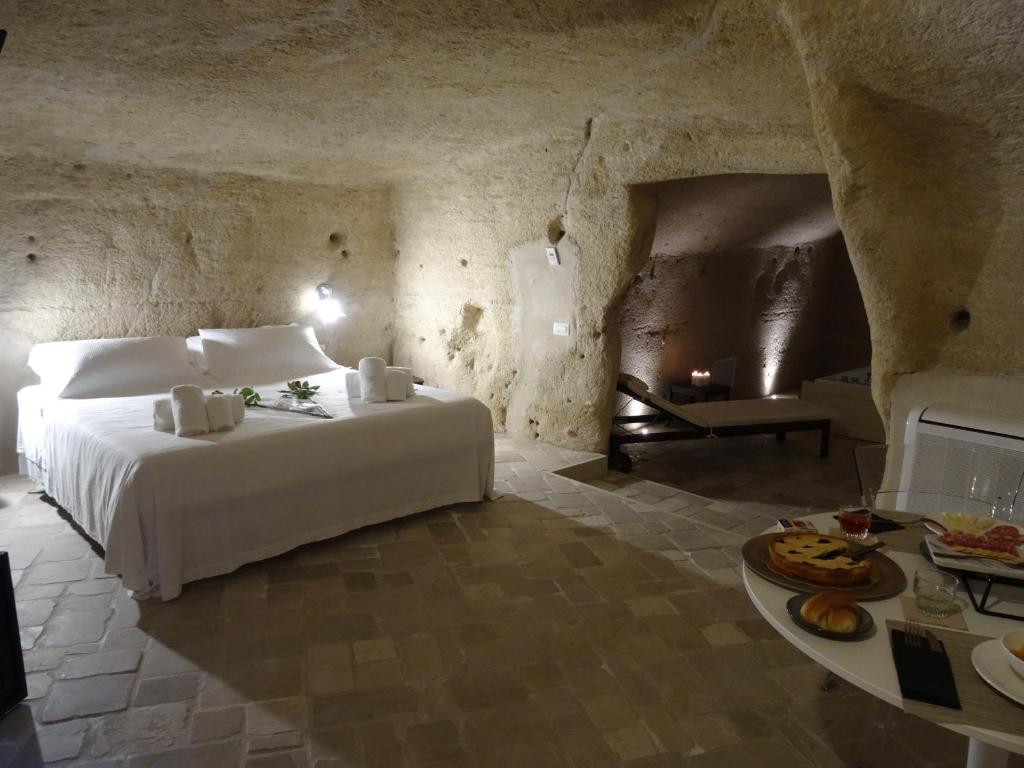 um quarto com uma cama branca e uma lareira em LA DIMORA DELLE 3 ZIE em Matera