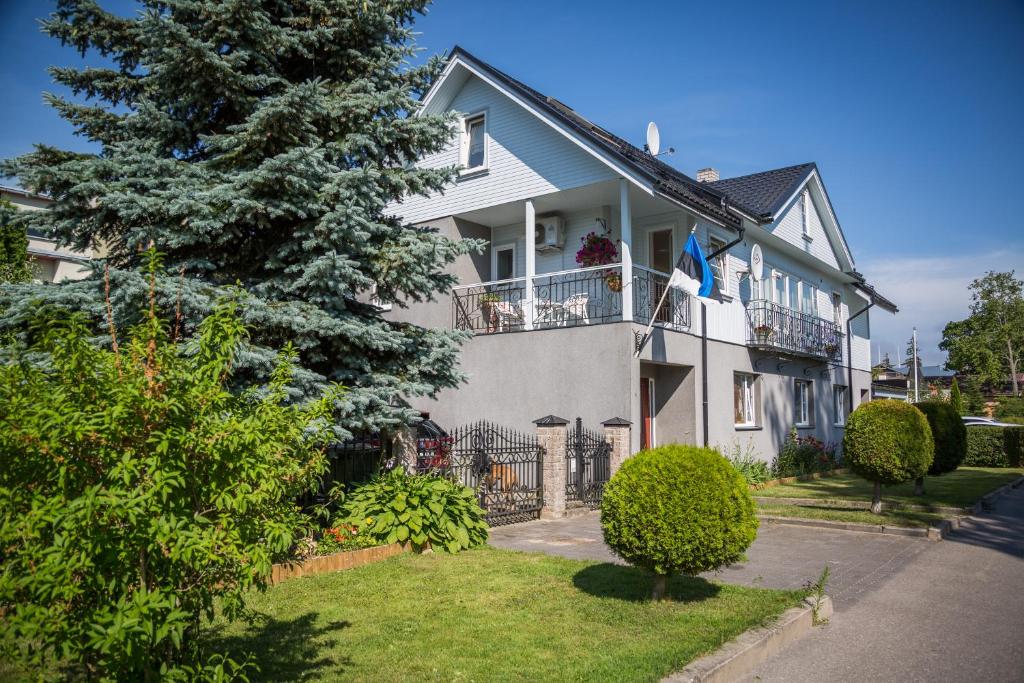 a white house with a tree in front of it at Papli 2 Accommodation in Pärnu