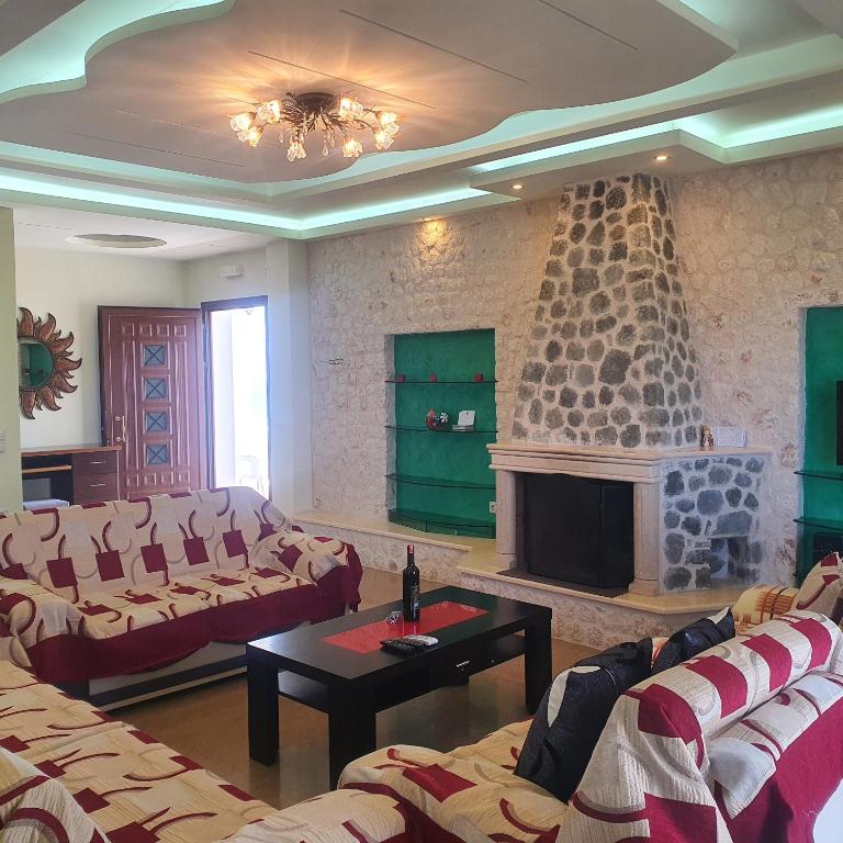 a living room with couches and a fireplace at Mihal Suites in Sarandë