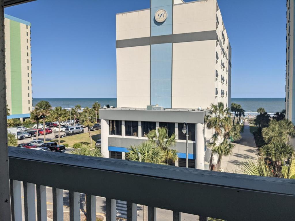a balcony with a view of a building and the ocean at Beach Side Hotel in Myrtle Beach