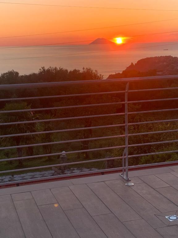 a sunset over the ocean with a fence at Hotel Royal in Coccorino